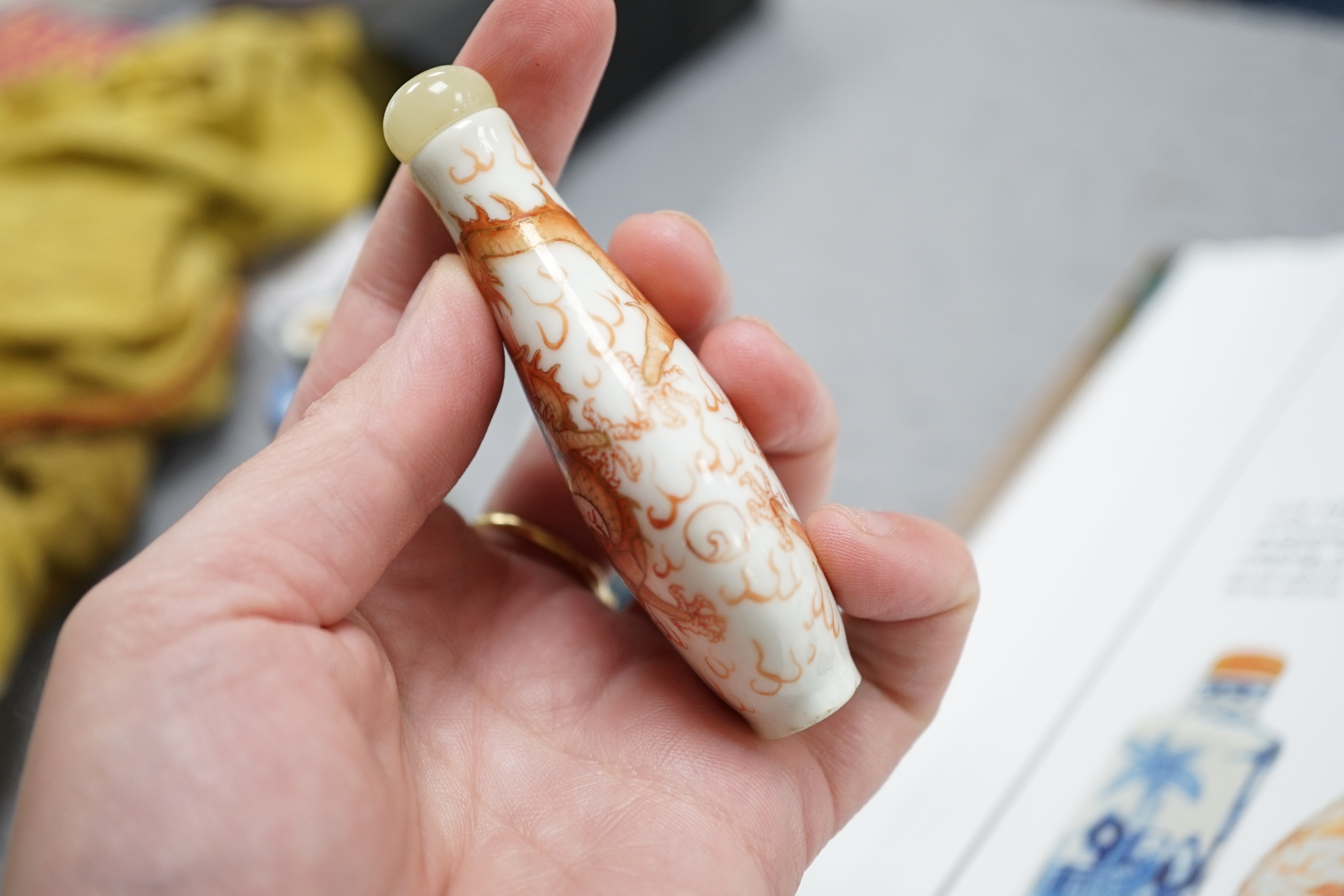 A Chinese iron red enamelled ‘dragon’ snuff bottle, Tongzhi mark and of the period (1862-74), together with two Chinese blue and white cylindrical snuff bottles, 19th century